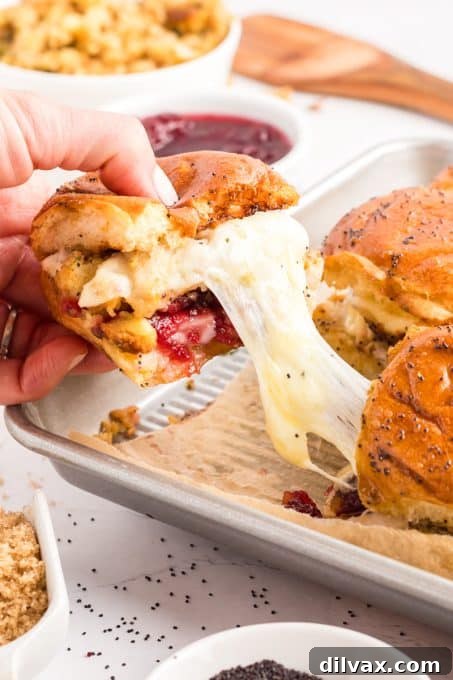 Sweet and Tangy Turkey Sliders 10 A delicious cheese pull from a Thanksgiving turkey slider.