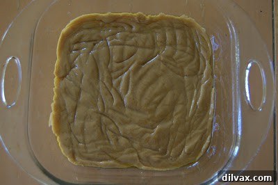 First layer of peanut butter batter spread evenly in the bottom of a square baking dish.