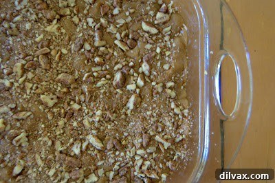 Candied pecans and turbinado sugar sprinkled over the top layer of batter, ready for baking.