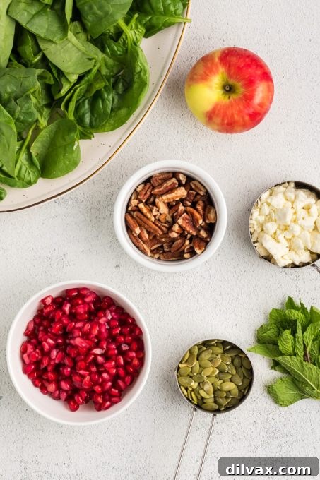 Winter Harvest Bowl 4 A collection of fresh ingredients laid out for a Winter Salad, including spinach, apples, feta, and nuts.
