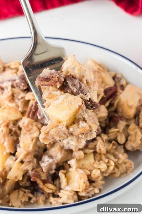 A bite of apple oatmeal baked in the oven on a spoon.
