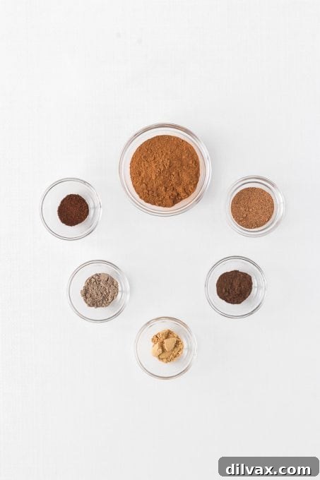 Autumn Spice Blend 4 Individual ground spices laid out on a wooden surface, ready to be blended into Apple Pie Spice.