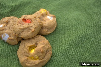 Freshly baked Pumpkin Candy Corn M&M Cookies cooling on a wire rack.