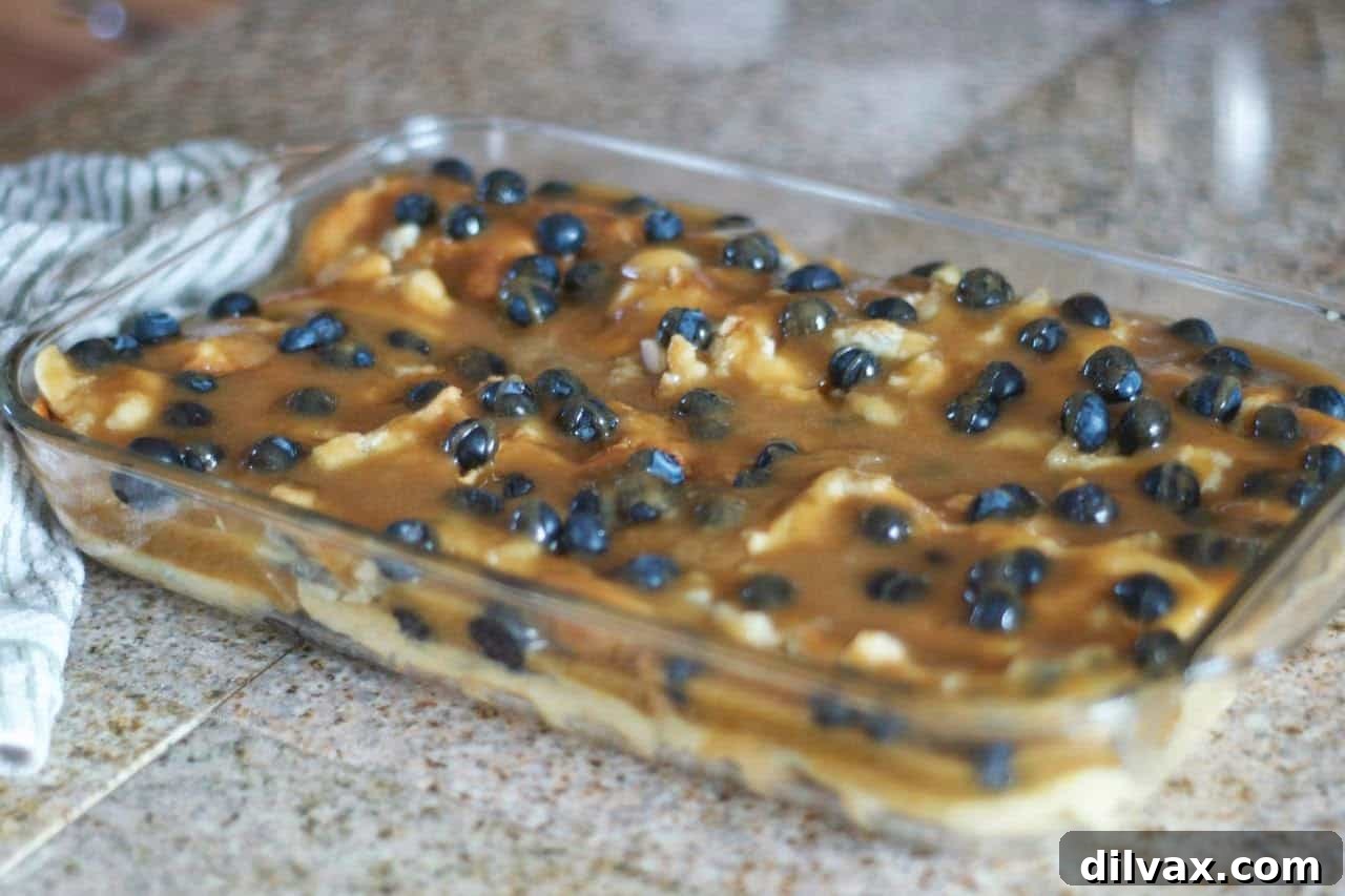 Baked Blueberry Waffles layered in a dish with brown sugar caramel sauce