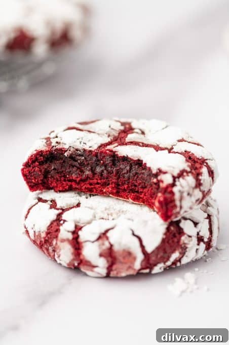 Red Velvet Crinkles 12 A Red Velvet Crinkle Cookie with a bite taken out of it, revealing its soft, red interior.