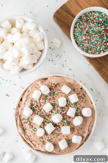 Hot cocoa dip lavishly topped with mini marshmallows and red and green sprinkles.