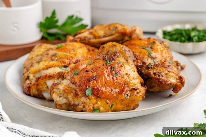 Crispy Air Fryer Chicken Thighs 2 Crispy Air Fryer Chicken Thighs on a plate with sides.