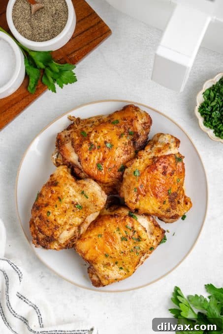 Crispy Air Fryer Chicken Thighs 12 Cooked Chicken Thighs for an easy weeknight dinner on a dark plate.