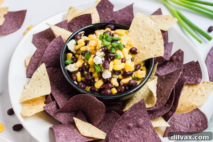 Delicious Black Bean, Corn, and Feta Dip served with crispy tortilla chips, perfect for game day or any gathering, showcasing vibrant colors and fresh ingredients.
