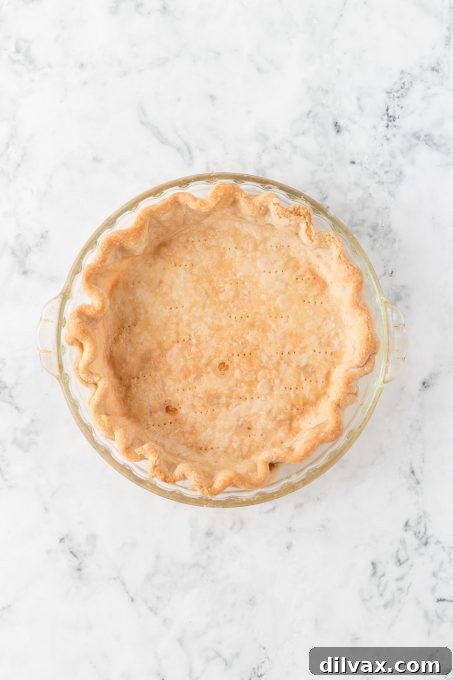 A perfectly fluted homemade pie crust made with shortening and butter, ready for filling.