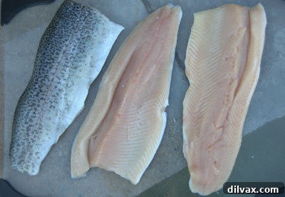 Trout fillets seasoned with salt and pepper in a baking dish, ready for the basil mixture.