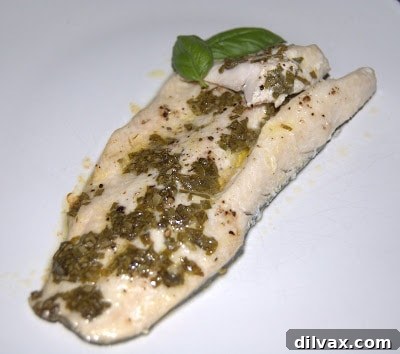 A perfectly baked Lemon Basil Trout fillet, golden and flaky, garnished with fresh basil.