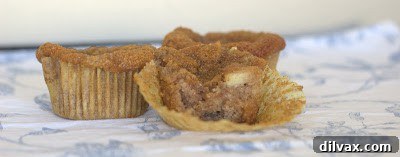Close-up of a baked almond apple muffin showing texture and apple chunks.
