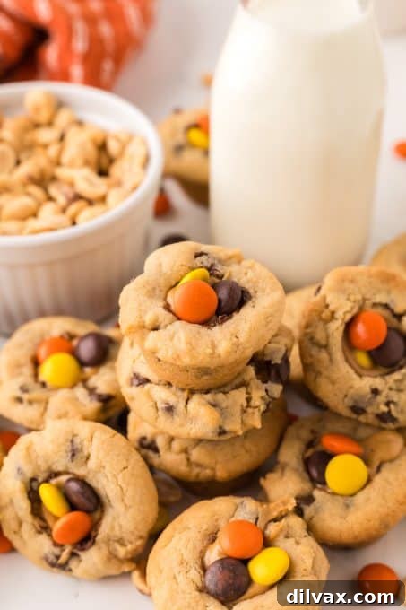 A stack of Reese's cookies generously filled with creamy peanut butter and topped with Reese's Pieces.