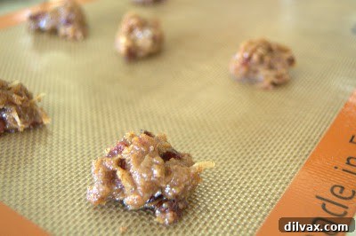 Unbaked cookie dough drops on a baking sheet lined with parchment paper.