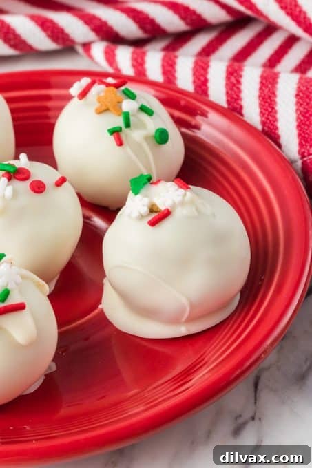 Spiced Holiday Truffle Treasures 3 Close-up of freshly dipped gingerbread truffles, half-coated in glistening white chocolate and festive sprinkles.