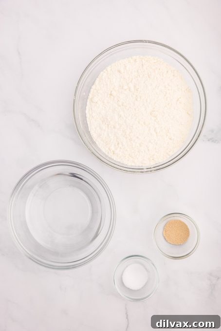 Key ingredients for making No-Knead Dutch Oven Bread laid out on a wooden surface.