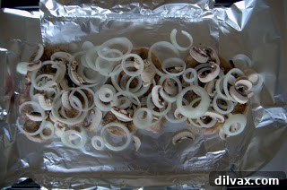 Slices of onion and mushroom layered on top of seared pork chops.