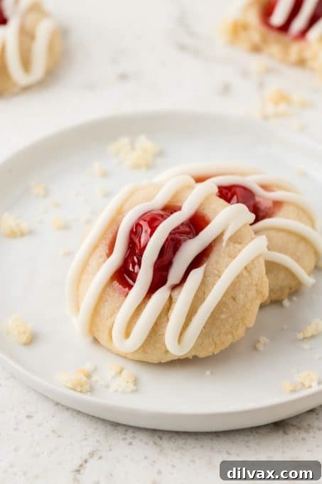 Cherry Thumbprint Delights 8 A tray of freshly baked Cherry Thumbprint Cookies, glistening with glaze.