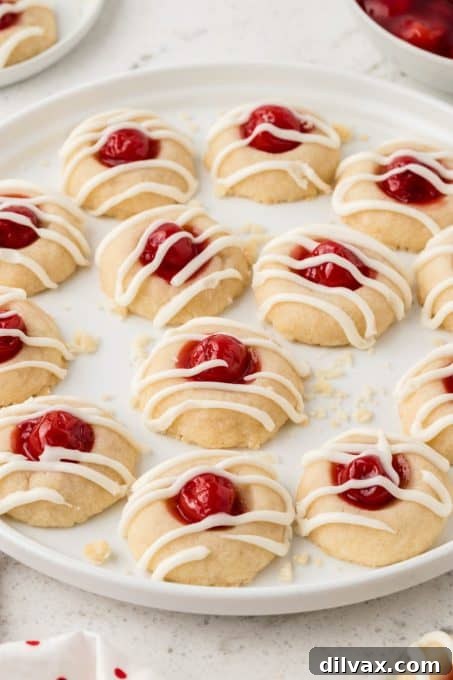 Cherry Thumbprint Delights 9 Cherry Thumbprint Cookies displayed on a white tray.