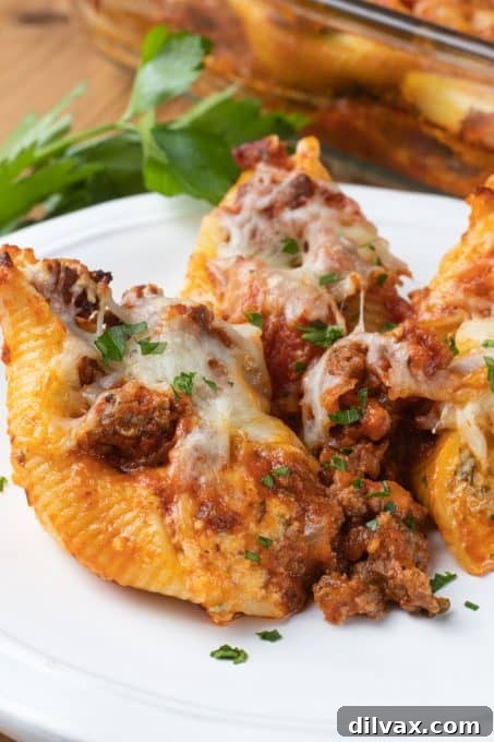 Hearty Baked Stuffed Shells 9 Two plates of baked stuffed shells with a fork