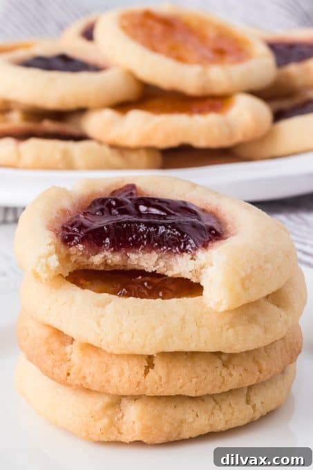 Jewel Box Cookies 12 A thumbprint cookie with a bite taken out, revealing the jelly filling.