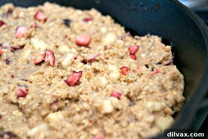 Cozy Skillet Apple Cranberry Oat Bake 12 A close-up shot of the Cranberry Apple Oatmeal Skillet Cookie, highlighting its rustic texture, baked-in cranberries, and golden-brown crust, emphasizing its comforting and delicious appeal.