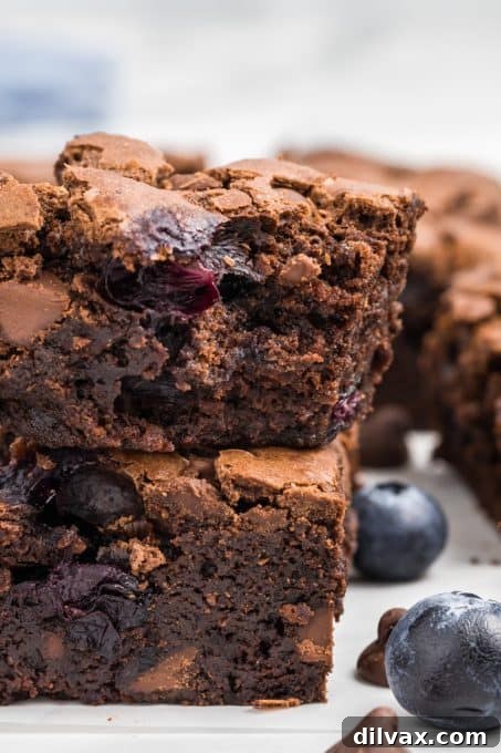 Decadent Blueberry Brownies 9 A bite taken out of a fudgy brownie filled with fresh blueberries, showing the moist texture.