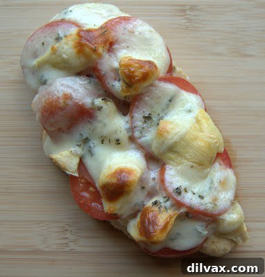 Close-up of a serving of Artichoke Tomato Chicken with melted cheese