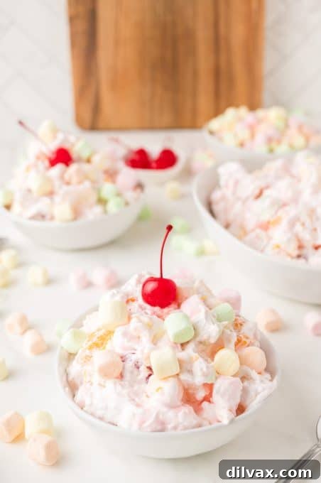 A fluffy fruit salad with mini marshmallows in a bowl.