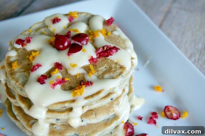 Fluffy Cranberry Pancakes with a generous Orange Cream Cheese Drizzle, served fresh.
