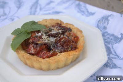 Two finished roasted tomato tartlets on a plate