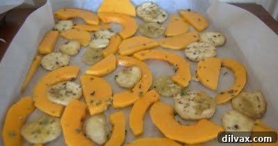 Butternut squash and eggplant spread out on baking sheets for roasting