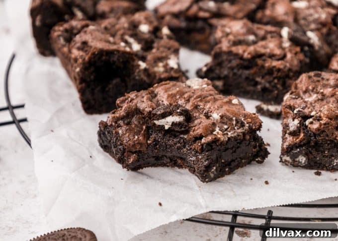 Fudgy Oreo Brownies with a crackly top, cut into squares on a cooling rack.