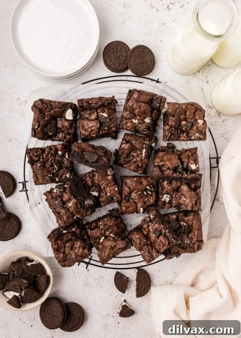 A tray of freshly baked, rich chocolate brownies with visible crushed sandwich cookies throughout.