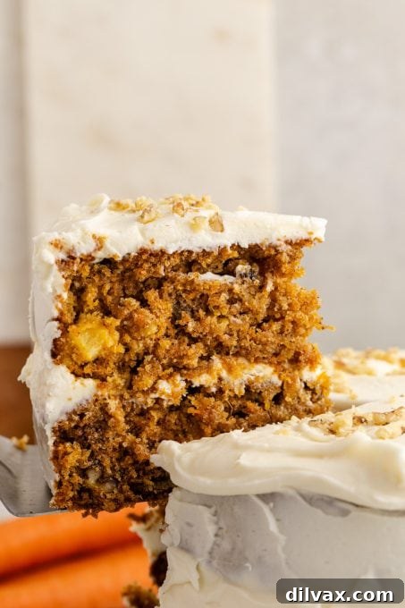 Close-up of a slice of carrot cake showing pineapple pieces.