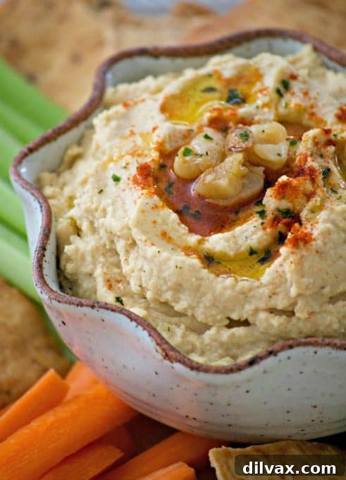 This Roasted Garlic Hummus is roasted cloves of garlic, tahini, lemon juice and spices. Served with pita chips or veggies, it's the perfect healthy treat.