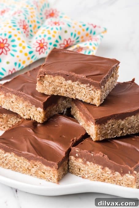 A stack of O'Henry Bars topped with chocolate and peanut butter, on a rustic surface.