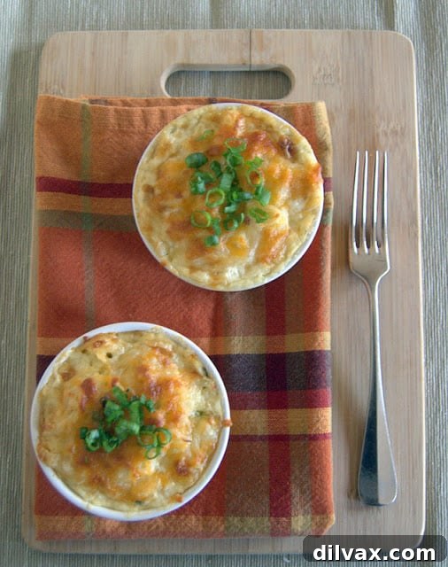 Individual serving of Potatoes Au Gratin in a ramekin, garnished with green onions