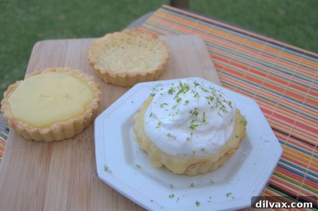 Zesty Lime Curd Tartlets 5 Finished lime curd tartlets garnished with whipped cream and lime zest