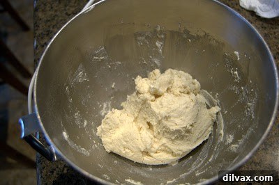 Round cookie dough pieces neatly arranged on a parchment-lined baking sheet.