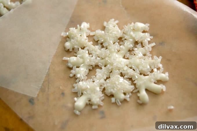 The Pressure Drop 10 Melted white chocolate piped into the shape of a snowflake and sprinkled with shimmer white sugar. These make adorable cupcake and cake toppers!