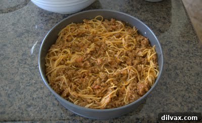 Spaghetti pie mixture poured into a springform pan.