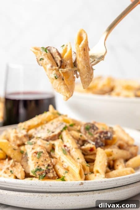 Overhead view of a large bowl of Creamy Mushroom Pasta with chicken, ready to be served family-style.