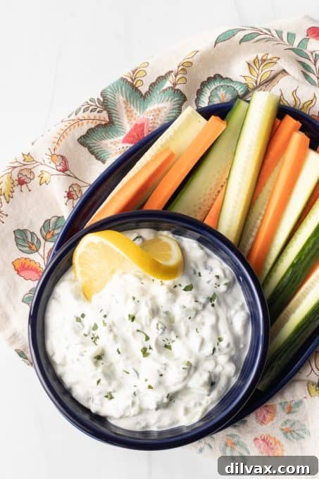Effortless Greek Tzatziki Dip 6 Tzatziki Sauce in a white bowl, garnished with fresh dill.