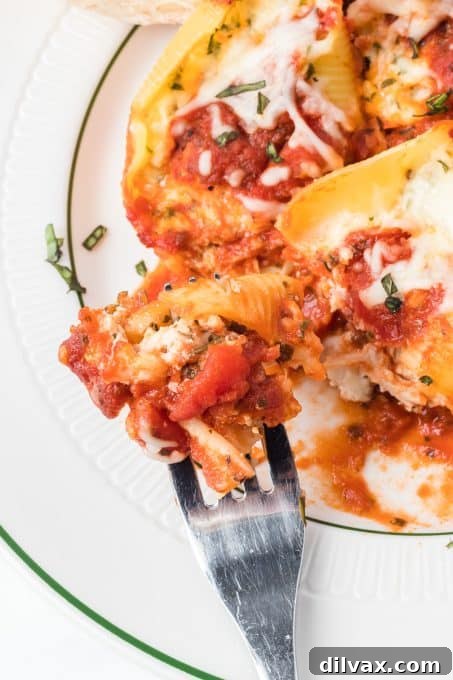 A fork taking a bite of cheese-stuffed chicken shells