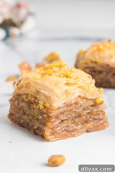 Close-up of golden Baklava layers, filled with walnuts and pistachios, glistening with honey syrup