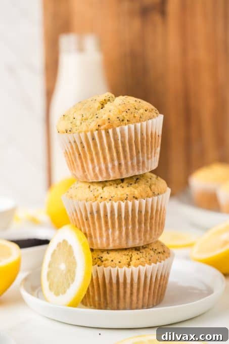 Citrus muffins with poppy seeds and a lemon glaze on a rustic wooden board.