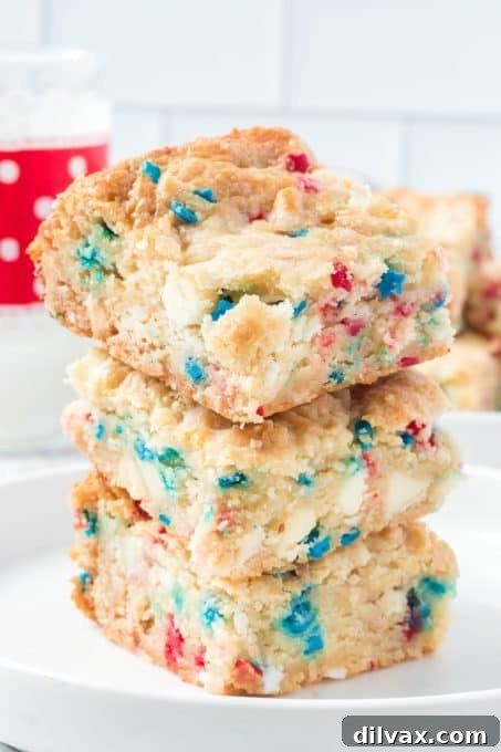 Stacked 4th of July Gooey Butter Bars on a white plate