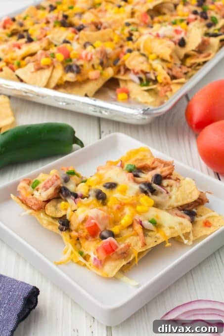 A close-up of a plate of BBQ Chicken Nachos, showing the tender chicken and melted cheese.